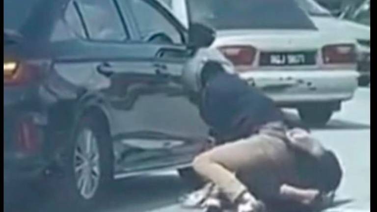 A video of the suspect pining down the 61-year-old victim to the ground before repeatedly punching him on the face was widely shared in the social media earning the wrath of netizens. Credit: Polis (IPD) Shah Alam/FACEBOOK