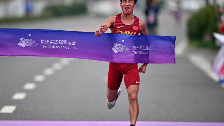 Asian Games - Hangzhou 2022 - Marathon - Qiantang River Green Belt, Hangzhou, China - October 5, 2023 China's He Jie crosses the line to win the gold medal in the Men's Marathon Final - REUTERSPIX