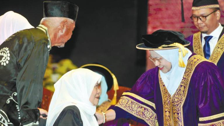 Yahani and Mazmon receiving Muhammad Fakhrur’s degree at the convocation ceremony in Shah Alam.