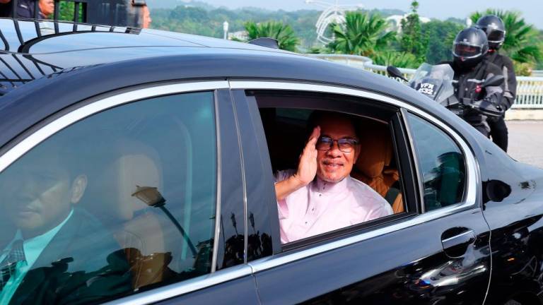 Perdana Menteri Datuk Seri Anwar Ibrahim melambaikan tangan kepada petugas media sejurus tiba di pekarangan Bangunan Perdana Putra untuk memulakan tugas hari pertama sebagai Perdana Menteri, hari ini./fotoBERNAMA