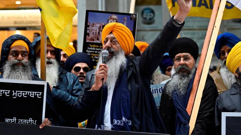 A demonstrator uses a microphone as others hold flags and signs as they protest outside India’s consulate, a week after Canada’s Prime Minister Justin Trudeau raised the prospect of New Delhi’s involvement in the murder of Sikh separatist leader Hardeep Singh Nijjar, in Vancouver, British Columbia, Canada September 25, 2023. REUTERSPIX