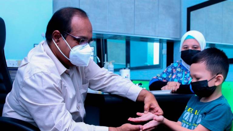 BUKIT MERTAJAM, 18 MEI - Pakar Kanak-kanak Hospital KPJ Specialist Pulau Pinang, Dr Abdul Nasir Mohamed memeriksa seorang kanak-kanak yang dijangkiti penyakit Tangan Kaki Dan Mulut (HFMD). MASRY CHE ANI/THESUN