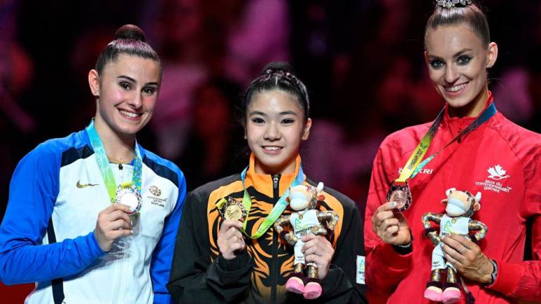 Silver medallist Scotland's Louise Christie (L), gold medallist Malaysia's Joe Ee Eng (C) and Bronze medallist Canada's Carmel Kallemaa pose during the medal ceremony for the ribbon rhythmic gymnastics event at the Arena Birmingham, on day nine of the Commonwealth Games in Birmingham, central England, on August 6, 2022. AFPPIX