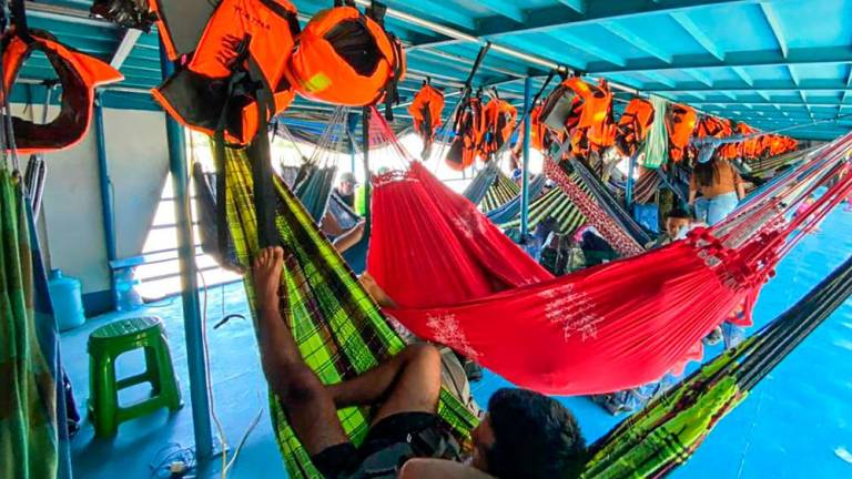 Foreign and Peruvian tourist rest in the boat where they have been detained at the Cuninico community in Loreto, north of Peru, on November 4, 2022. AFPPIX