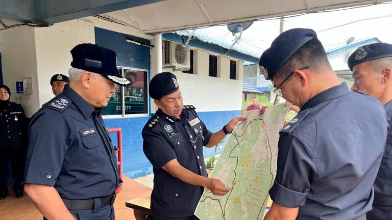 BATU PAHAT, Jan 29 -- Inspector-General of Police Tan Sri Acryl Sani Abdullah Sani (left) looks at a map of the flood area in Batu Pahat district involving Sri Medan and Yong Peng areas. BERNAMAPIX