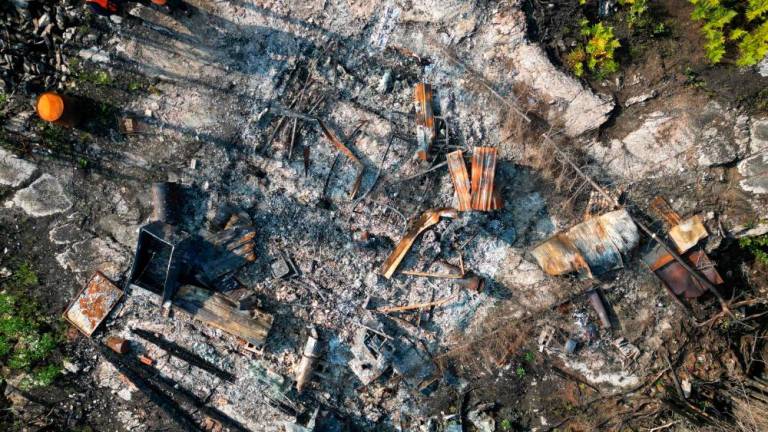 In this aerial photo, Omer Riviere and Serge Racette stand in front of Omer’s destroyed hunting camp in the forest around the village of Normétal in West Quebec, Canada, on September 22, 2023. AFPPIX