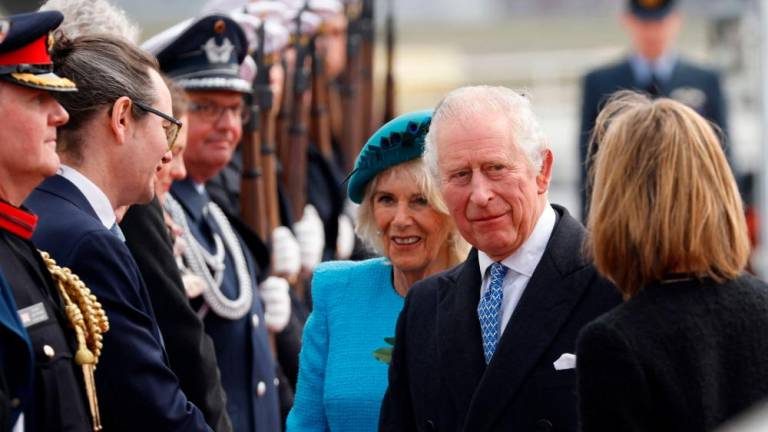 Britain’s King Charles III (2R) shakes hands next to Britain’s Camilla, Queen Consort and British Ambassador to Germany Jill Gallard (R) after landing at Berlin Brandenburg Airport in Schoenefeld near Berlin, on March 29, 2023. AFPPIX