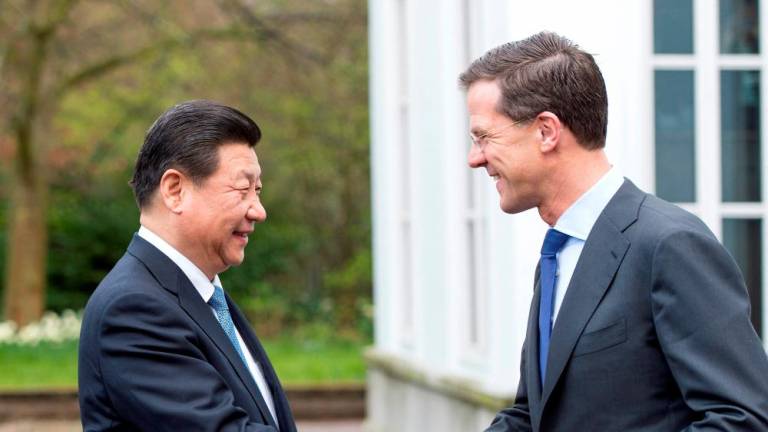 FILE PHOTO: Prime Minister Mark Rutte (R) of the Netherlands shakes hands with China’s President Xi Jinping as he welcomes Xi on the second day of his state visit, at The Hague March 23, 2014. REUTERSPIX