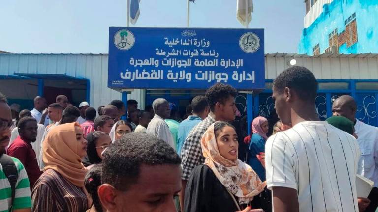 Sudanese queue outside a passport office in Gedaref, desperate to renew the travel documents that will allow them to flee the fighting gripping the country. AFPPIX