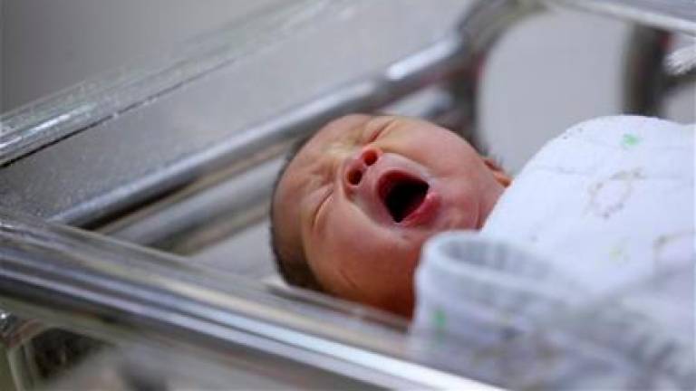 A baby yawns inside the maternity ward of a hospital. REUTERSPIX