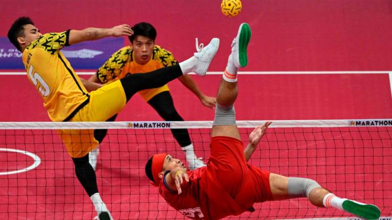 Thailand's Varayut Jantarasena (R) kicks the ball as Malaysia's Mohamad Azlan Bin Alias (L) defends in the men's team final of the sepak takraw event during the Hangzhou 2022 Asian Games in Jinhua in China's eastern Zhejiang province on September 29, 2023. AFPPIX