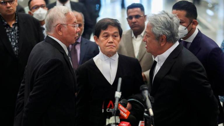 Former Malaysian Prime Minister Najib Razak speaks to his lawyers Hisyam Teh Poh Teik (center) and Zaid Ibrahim during a news conference at the Federal Court in Putrajaya, Malaysia August 16, 2022. REUTERSPIX
