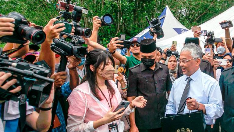 The Yang di-Pertuan Agong handing out food packages to media personnel outside Istana Negara on Monday. – AMIRUL SYAFIQ/THESUN