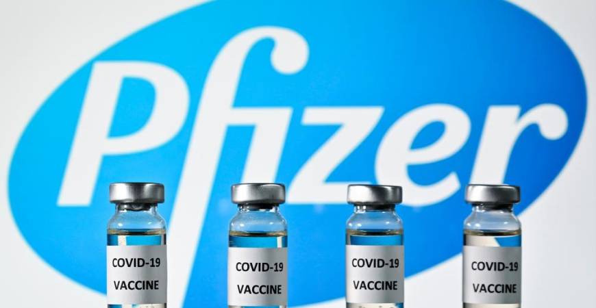 (FILES) This file photo illustration picture shows vials with Covid-19 Vaccine stickers attached, with the logo of US pharmaceutical company Pfizer, on November 17, 2020. Pfizer and BioNTech said on November 18, 2020 a completed analysis of their experimental Covid-19 vaccine found it protected 95 percent of people against the disease and announced they were applying for US emergency approval “within days.”AFP / JUSTIN TALLIS