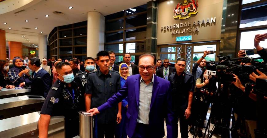 Anwar scanning his access card before clocking in as finance minister at the Finance Ministry complex in Putrajaya yesterday. – Bernamapic