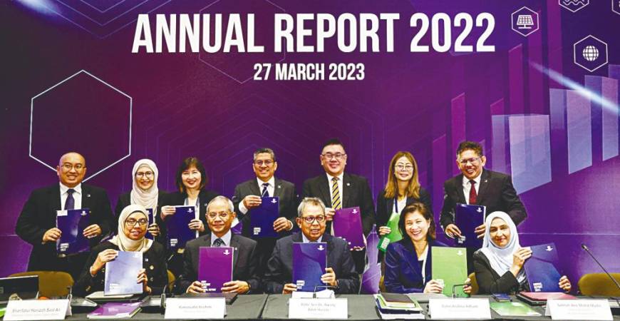 Awang Adek (seated, centre) with SC senior management displaying the commission’s annual report. – Bernamapic
