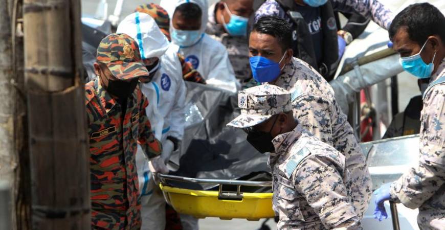 Gambar menunjukkan anggota Bomba dan Penyelamat bersama anggota Agensi Penguatkuasaan Maritim mengusung salah seorang mangsa karam di Jeti Persatuan Nelayan Pontian Besar hari ini. fotoBERNAMA