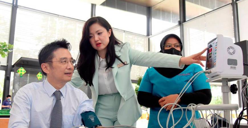 Diana Tan (centre) explains to Ter Leong Yap (left) about his blood pressure reading at the newly launched Sunsuria Care Hub.