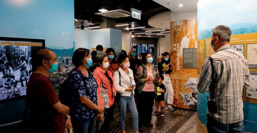 FILE PHOTO: Tourists wearing face masks listen to an instructor inside Hong Kong News-Expo during a Hong Kong Tourism Board’s free local tour, following the coronavirus disease (COVID-19) outbreak, in Hong Kong, China November 1,2020. REUTERS/Tyrone Siu/File Photo