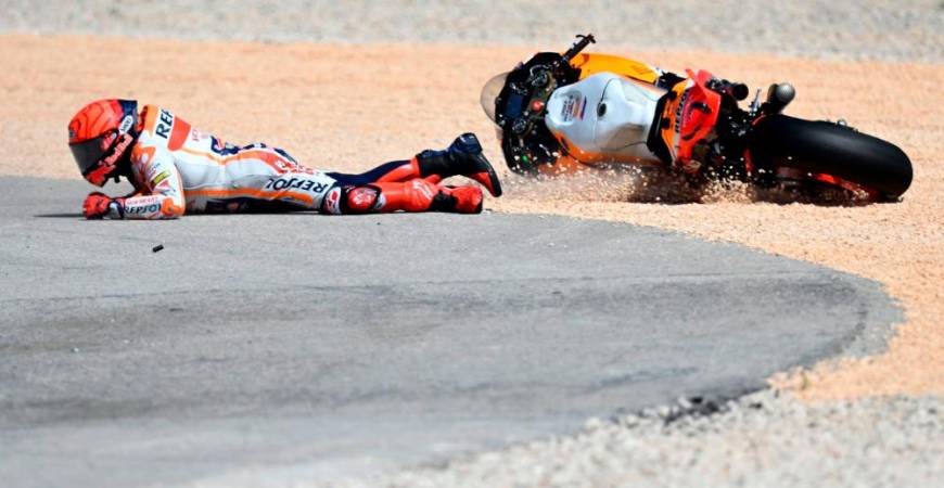 Honda Spanish rider Marc Marquez falls after crashing with Aprilia Portuguese rider Miguel Oliveira (out of frame) during the MotoGP race of the Portuguese Grand Prix at the Algarve International Circuit in Portimao, on March 26, 2023. AFPPIX