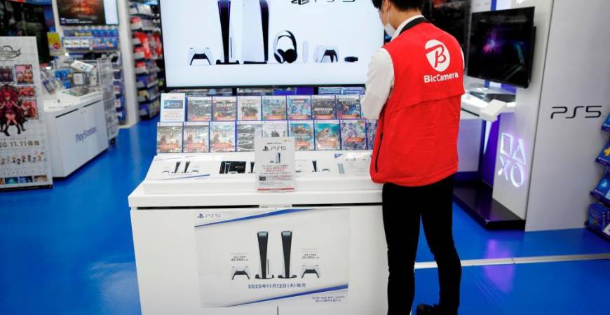 An employee of the consumer electronics retailer chain Bic Camera works at the promotion display for the Sony PlayStation 5 game console and its gaming softwares in Tokyo, Japan, November 10, 2020. Picture taken November 10, 2020. REUTERS/Issei Kato
