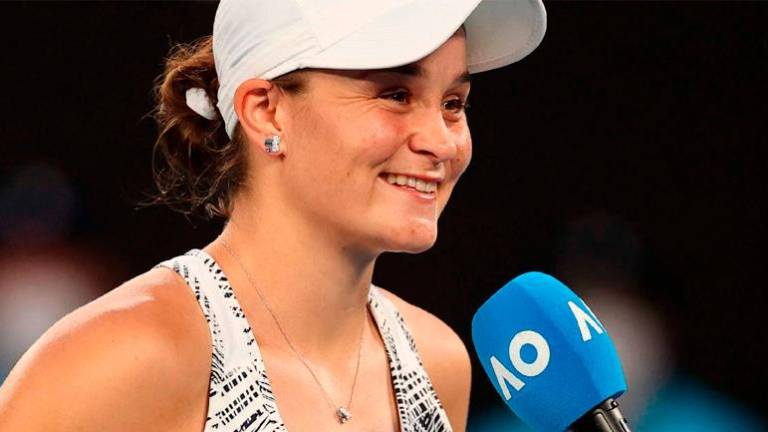Australia’s Ashleigh Barty takes part in an interview on court after beating Jessica Pegula (unseen) of the US in their women’s singles quarterfinal match on day nine of the Australian Open in Melbourne on Jan 25, 2022. – AFPPIX