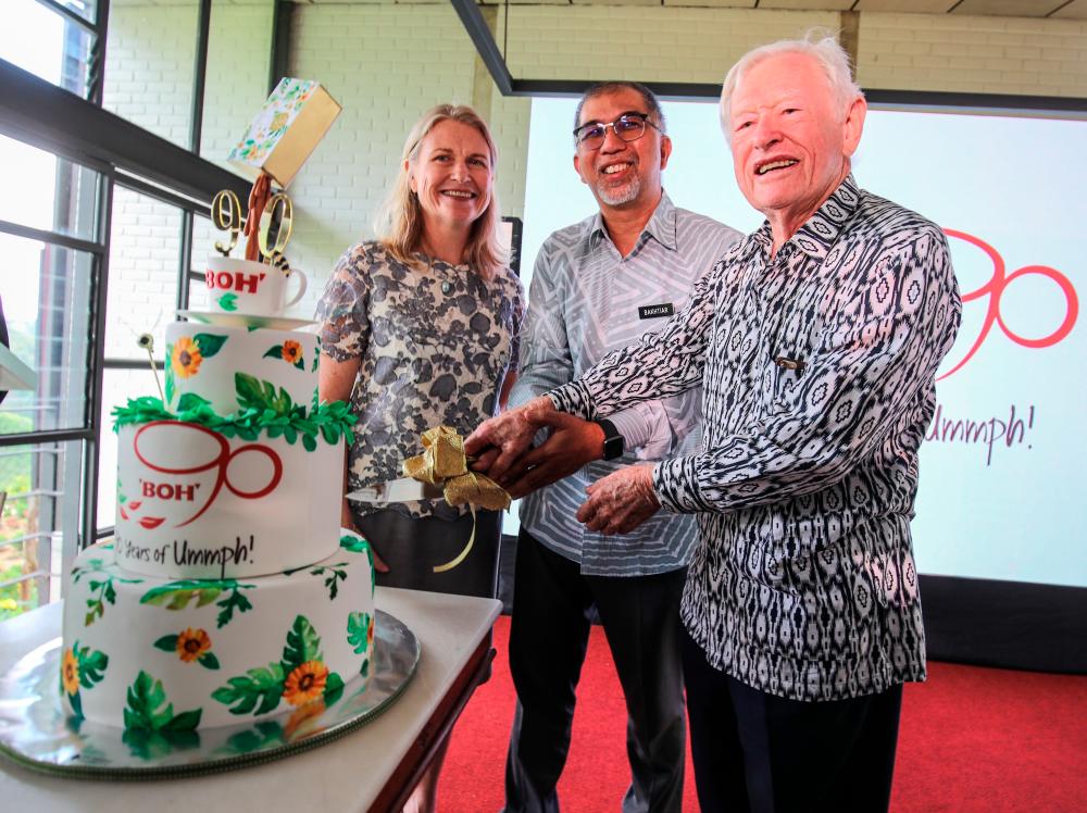 (L to R) Boh Plantations executive chairman Caroline Russell, Tourism, Arts and Culture Deputy Minister Muhammad Bakhtiar Wan Chik, and Datuk Tristan Russell cutting a cake to mark Boh’s 90th anniversary at Boh’s Sungei Palas Tea Centre in Cameron Highlands. – Sunpix by Amirul Syafiq Mohd Din