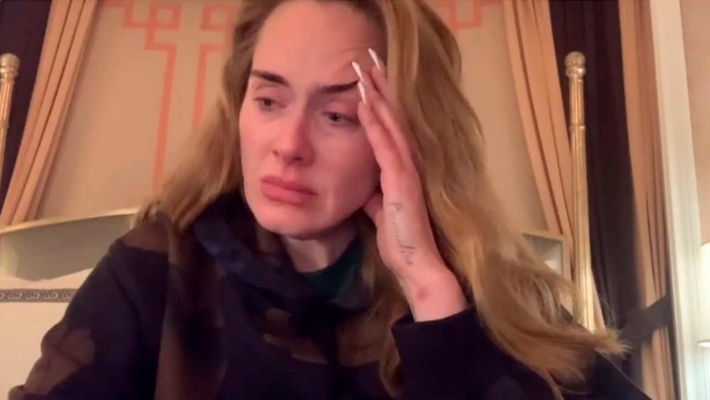 A screenshot from the video showing a tearful Adele informing fans of the delay in beginning her Las Vegas residency.