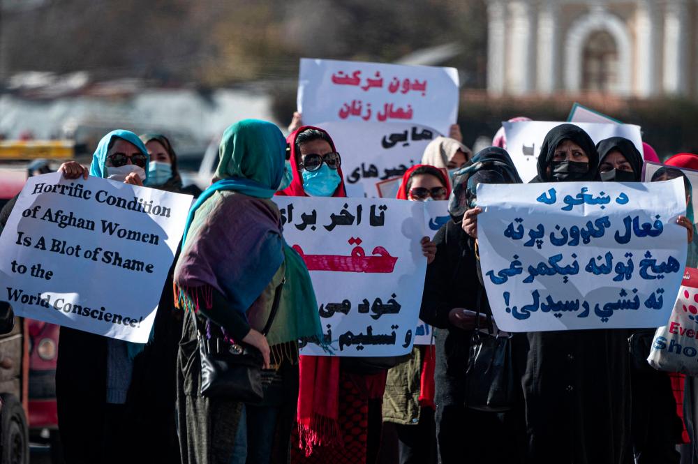 Women hold placards during a protest calling for their rights to be recognised, near the Shah-e-Do Shamshira mosque in Kabul on November 24, 2022. - AFPPIX