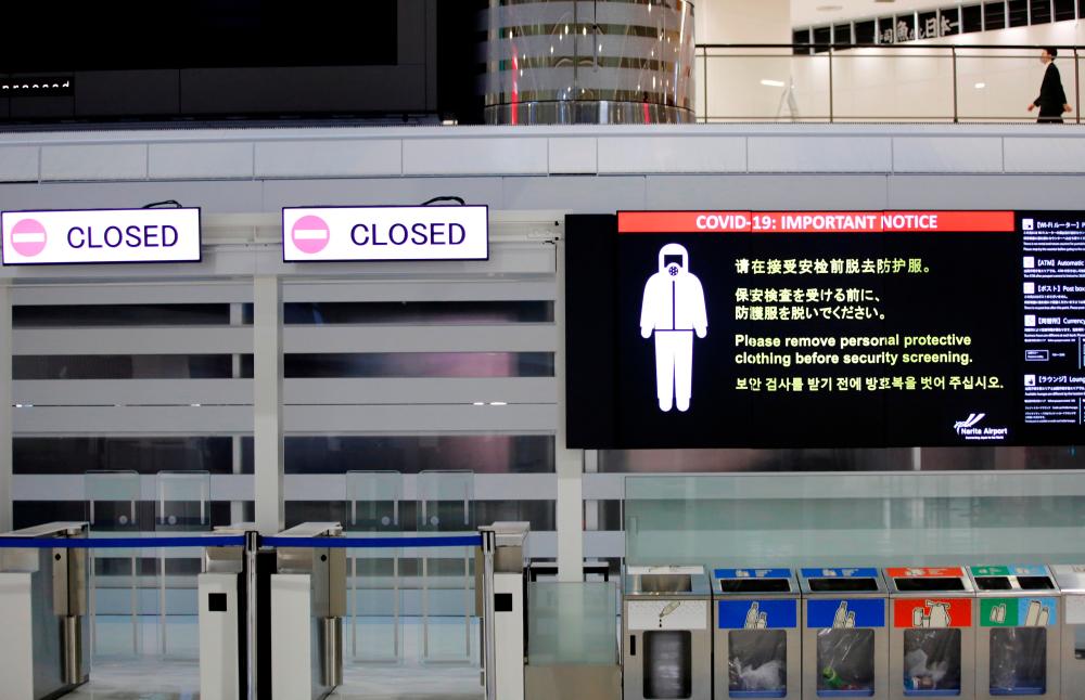 FILE PHOTO: A notice about Covid-19 safety measures is pictured next to closed doors at a departure hall of Narita international airport on the first day of closed borders to prevent the spread of the new coronavirus Omicron variant in Narita, east of Tokyo, Japan, November 30, 2021. REUTERSpix