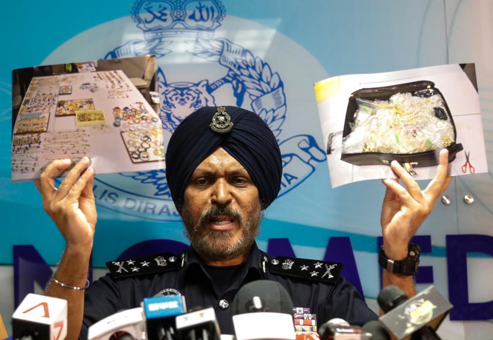 Former Federal CCID director Datuk Seri Amar Singh showing photographs of the items seized from residences linked to former Prime Minister Datuk Seri Najib Abdul Razak during a press conference on June 27, 2018. — Sunpix by Asyraf Rasid