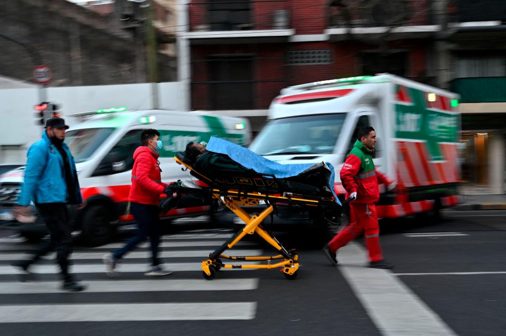 Paramedics carry an injured person on a stretcher during a fire in an apartment building at Recoleta neighborhood in Buenos Aires, on June 23, 2022. AFPPIX