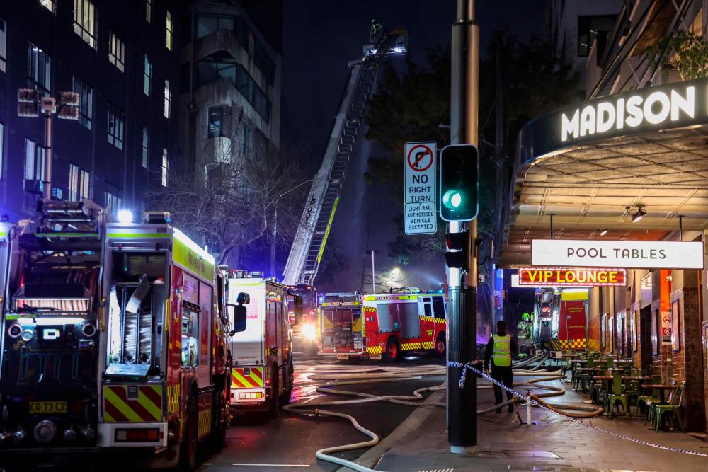 Firemen work at the scene of a fire at a building in Sydney on May 25, 2023. AFPPIX