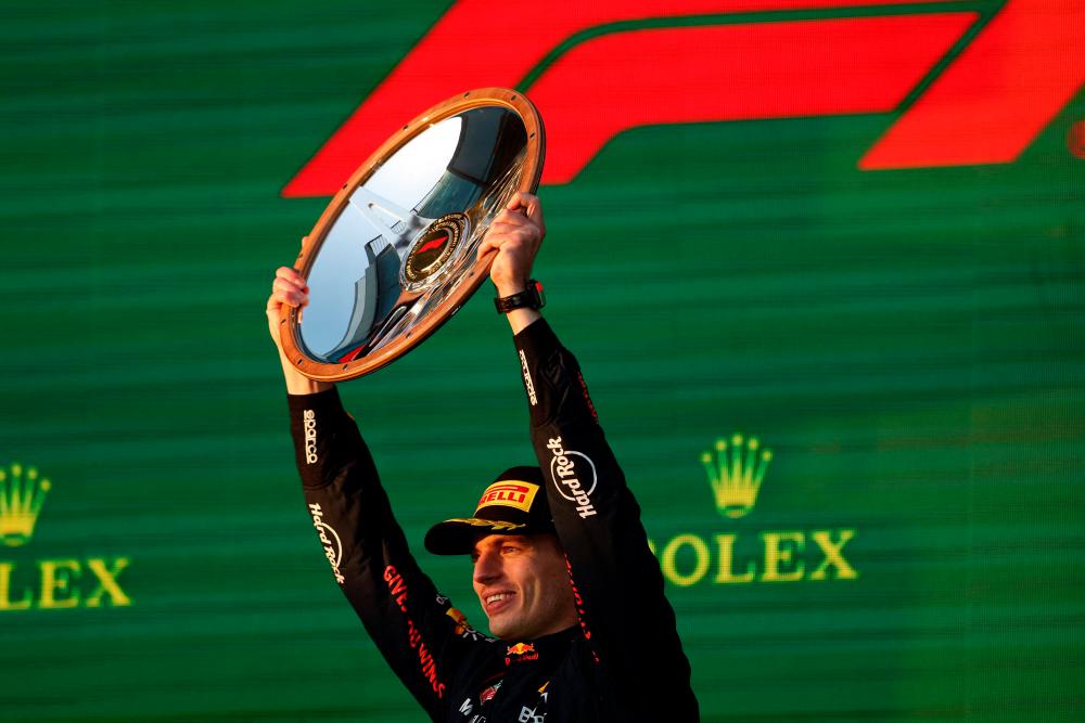 Red Bull Racing’s Dutch driver Max Verstappen celebrates victory with the trophy on the podium after the 2023 Formula One Australian Grand Prix at the Albert Park Circuit in Melbourne on April 2, 2023. AFPPIX