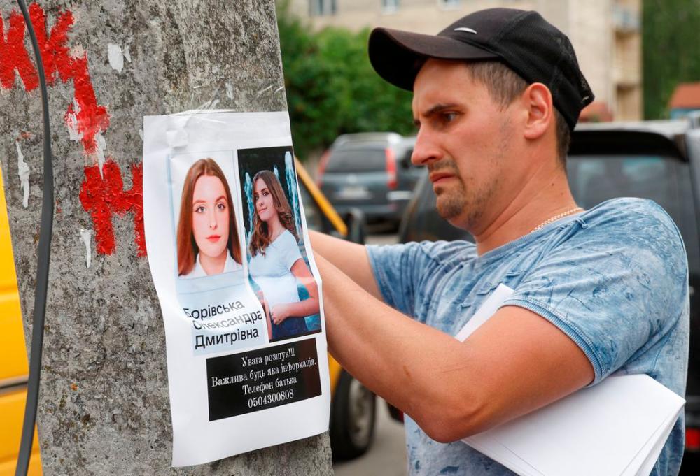 A man place a poster advertisement about a missing person, at site of a Russian missile strike, as Russia’s attack on Ukraine continues, in Vinnytsia, Ukraine July 15, 2022. REUTERSPIX