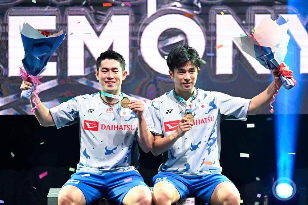 Yugo Kobayashi (B) dan Takuro Hoki (R) dari Jepun bergambar dengan pingat emas selepas memenangi acara beregu lelaki pada kejohanan badminton Petronas Terbuka Malaysia 2022 di Kuala Lumpur pada 3 Julai 2022.