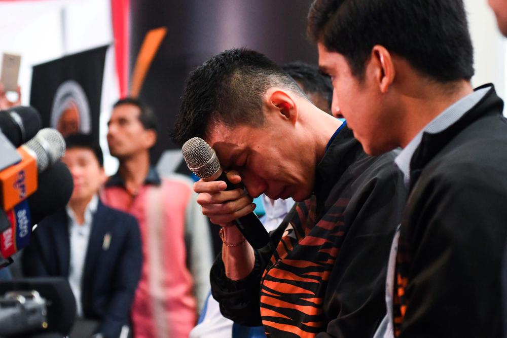 Badminton player Datuk Lee Chong Wei (C) reacts during a press conference to announce his retirement in Putrajaya on June 13, 2019. — AFP