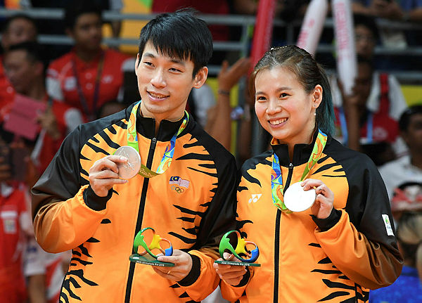 Silver medalists Liu Ying Goh and Malaysia’s Peng Soon Chan stand with their medals on the podium following the mixed doubles Gold Medal badminton match at the Riocentro stadium in Rio de Janeiro on Aug 17, 2016, at the Rio 2016 Olympic Games. — AFP