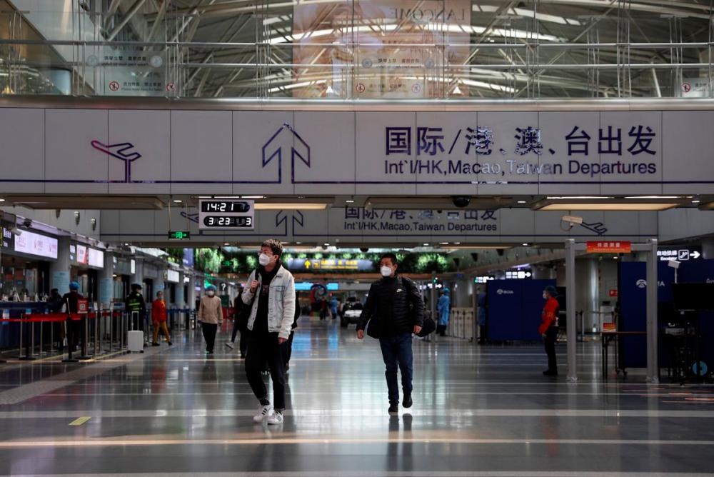 Travellers walk at a terminal hall of the Beijing Capital International Airport in Beijing, China March 23, 2022. REUTERSpix