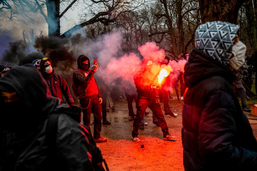 Protestors film and hold smoke bombs during a demonstration for “freedom, democracy and human rights” organised by the alliance Europeans United in Brussels, on January 23, 2022. AFPPIX