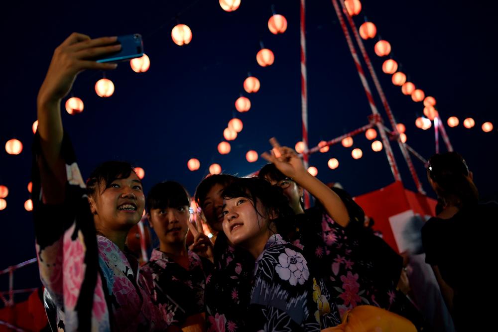 File photo: In this picture taken July 22, 2017 Japanese girls living in Malaysia wearing traditional Kimono costume pose for a selfie during the annual 'Bon Odori' festival celebrations in Shah Alam. AFPpix