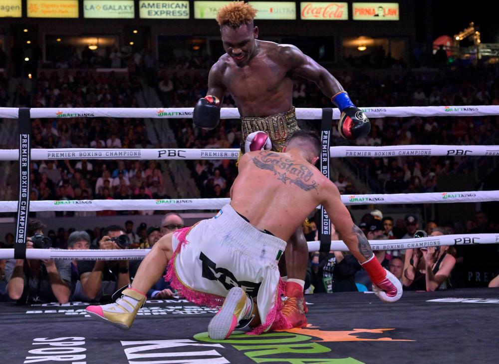 CARSON, CA - MAY 14: Jermell Charlo (gold/red shorts) knocks down Brian Castano (white/pink shorts) during their super middleweight title fight at Dignity Health Sports Park on May 14, 2022 in Carson, California. Charlo won by knockout in the 10th round. AFPPIX
