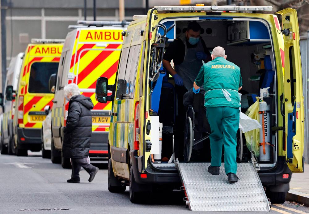 Paramedics works inside an ambulance parked outside the Royal London hospital in London on December 20, 2021. AFPPIX