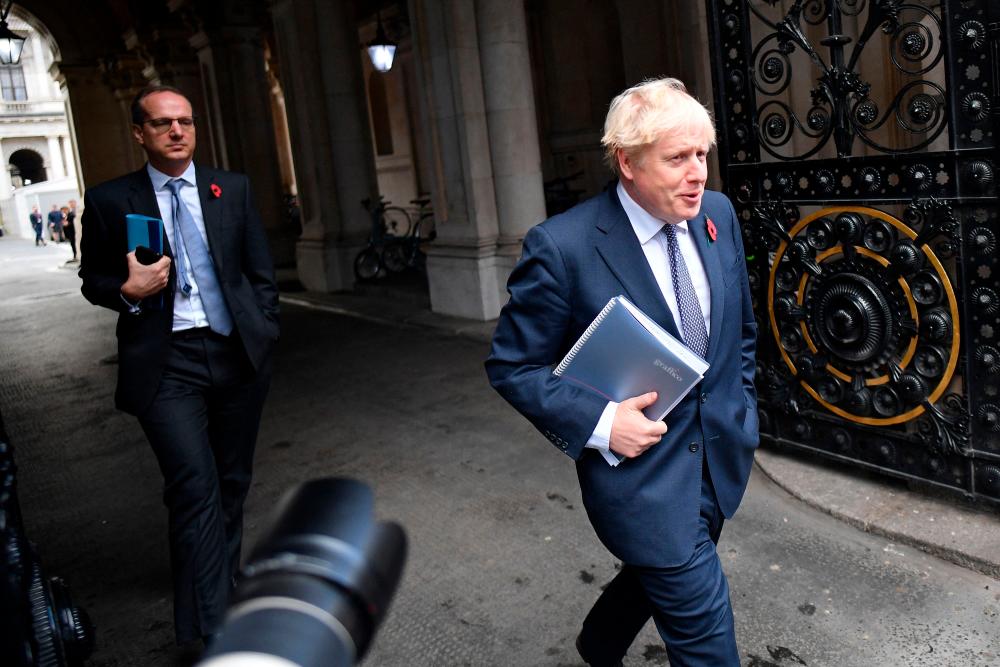Britain’s Prime Minister Boris Johnson (R) and Martin Reynolds, the Prime Minister’s Principal Private Secretary (L), arrive back at Downing Street in London on November 10, 2020 after chairing the weekly cabinet meeting held at the nearby Foreign, Commonwealth and Development Office. AFPPIX