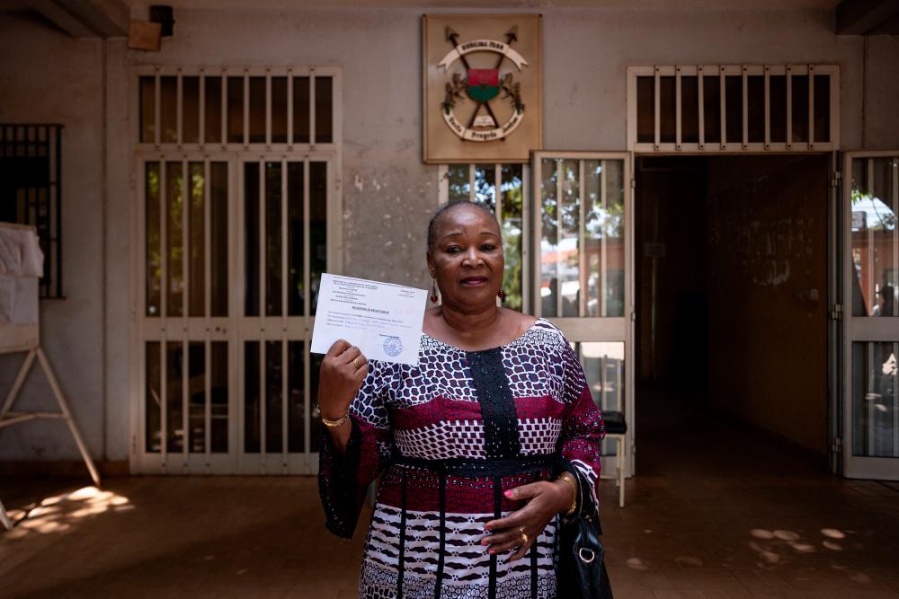 Edwige Nikiéma, a 60 year old housewife, poses with his receipt after enlisting as a Volunteers for the Defence of the Homeland (VDP), at the governorate of Ouagadougou, in Burkina Faso on November 18, 2022. - AFPPIX