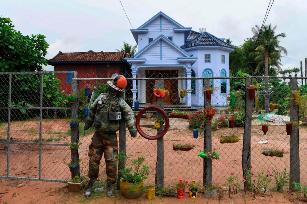 $!A scarecrow is pictured tied to a fence in front of a house in Cambodia’s Kampong Thom province on October 11, 2020, as superstitious residents in the region set up the sentries known as “Ting Mong” in Khmer to ward off the COVID-19 coronavirus during the pandemic. / AFP / TANG CHHIN Sothy