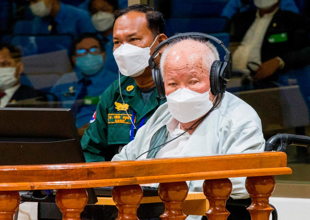 This handout photo taken and released by the Extraordinary Chamber in the Courts of Cambodia (ECCC) on September 22, 2022 shows ex-Khmer Rouge head of state Khieu Samphan (R) sits in the court room at the Extraordinary Chamber in the Courts of Cambodia (ECCC) in Phnom Penh. AFPPIX
