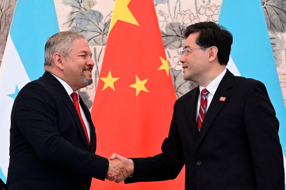 Honduras Foreign Minister Eduardo Enrique Reina (L) and Chinese Foreign Minister Qin Gang shake hands following the establishment of diplomatic relations between the two countries, during a joint statement after a ceremony in the Diaoyutai State Guesthouse in Beijing on March 26, 2023. AFPPIX