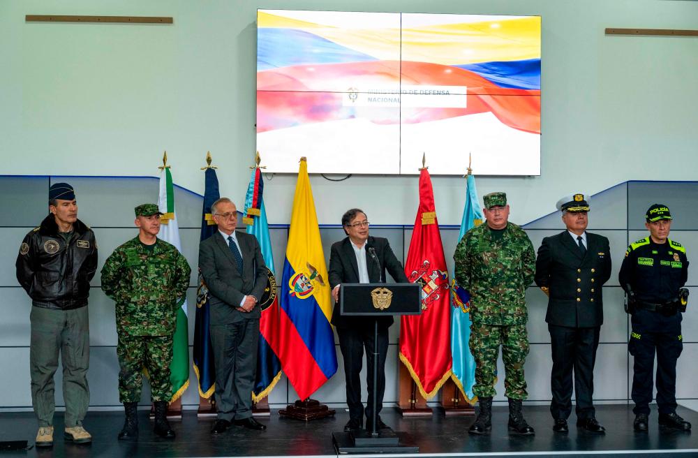 Handout picture released by Colombia’s Ministry of Defence press office showing Colombia’s President Gustavo Petro (C) delivering a speech during the presentation of the military leadership, in Bogota on August 12, 2022 as Defence Ivan Velasquez (3-L), the Commander of the Military Forces, general Helder Giraldo (3-R), the Chief of the Joint Chiefs of Staff, Vice Admiral Jose Amezquita (2-R), the Director of the National Police, Henry Sanabria (R), the Commander of the Air Force, Luis Cordoba (L), and the Commander of the National Army, Luis Ospina (2-L), stand on the stage with him. AFPPIX