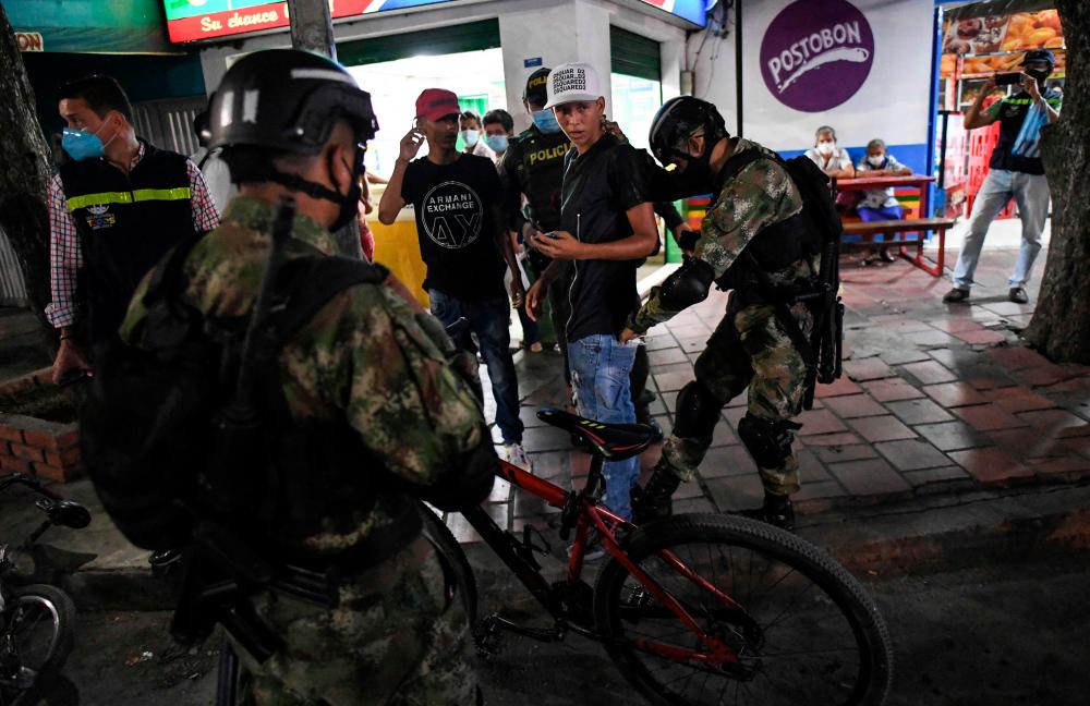 A Colombian soldier frisks a local at a checkpoint in Cuberos Nino neighbourhood in Cucuta, in the Colombia-Venezuela border on October 5, 2021. AFPPIX
